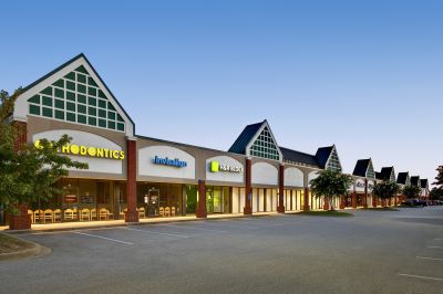 Commercial retail strip center with green gabled rooflines housing medical and service tenants in Memphis corporate real estate.