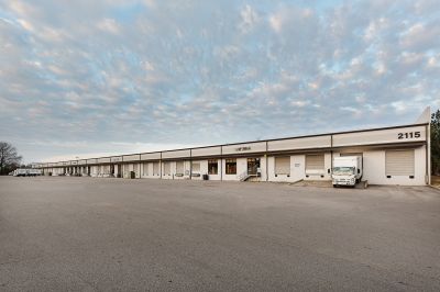 Wide exterior view of an industrial distribution center with loading docks and a delivery truck in the Memphis corporate real estate market.