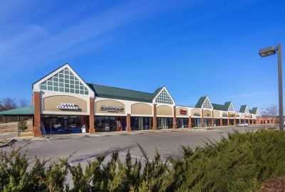 Exterior view of the Shops at Countrybridge retail center featuring brick columns and green roof accents in Memphis corporate real estate.