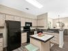 Model apartment kitchen interior at Westbury Apartments featuring black appliances, light wood cabinets, and a prep island