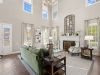 Spacious clubhouse sitting room at Westbury Apartments featuring vaulted ceilings, large windows, a fireplace, and green seating