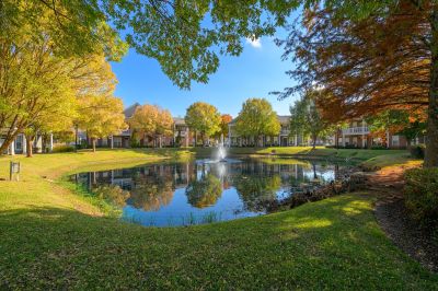 Picturesque pond and fountain reflecting autumn trees surrounding Westbury Apartments