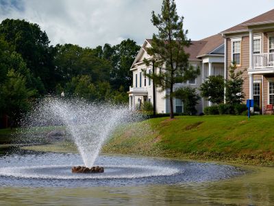 Central water fountain spraying in a scenic pond in front of multi-family buildings at Westbury Apartments in Memphis