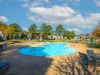 Large outdoor swimming pool and sun lounge deck at Champion Hills