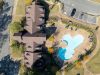 Aerial drone view showing apartment building rooflines and pool amenities