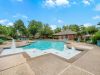 Spacious swimming pool with built-in decorative water fountains and lounge seating