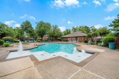 Spacious swimming pool with built-in decorative water fountains and lounge seating