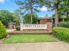 Brick and stone entrance monument sign for Monticello Apartments surrounded by landscaped greenery