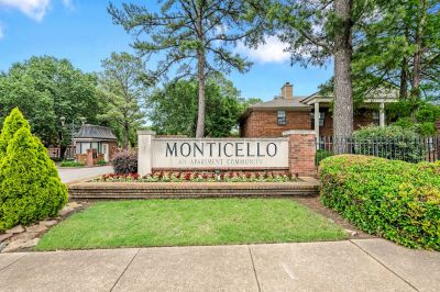 Brick and stone entrance monument sign for Monticello Apartments surrounded by landscaped greenery