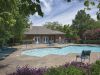 Resort-style outdoor community swimming pool and lounge area in an apartment complex.