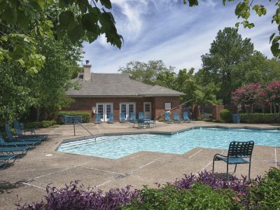 Resort-style outdoor community swimming pool and lounge area in an apartment complex.